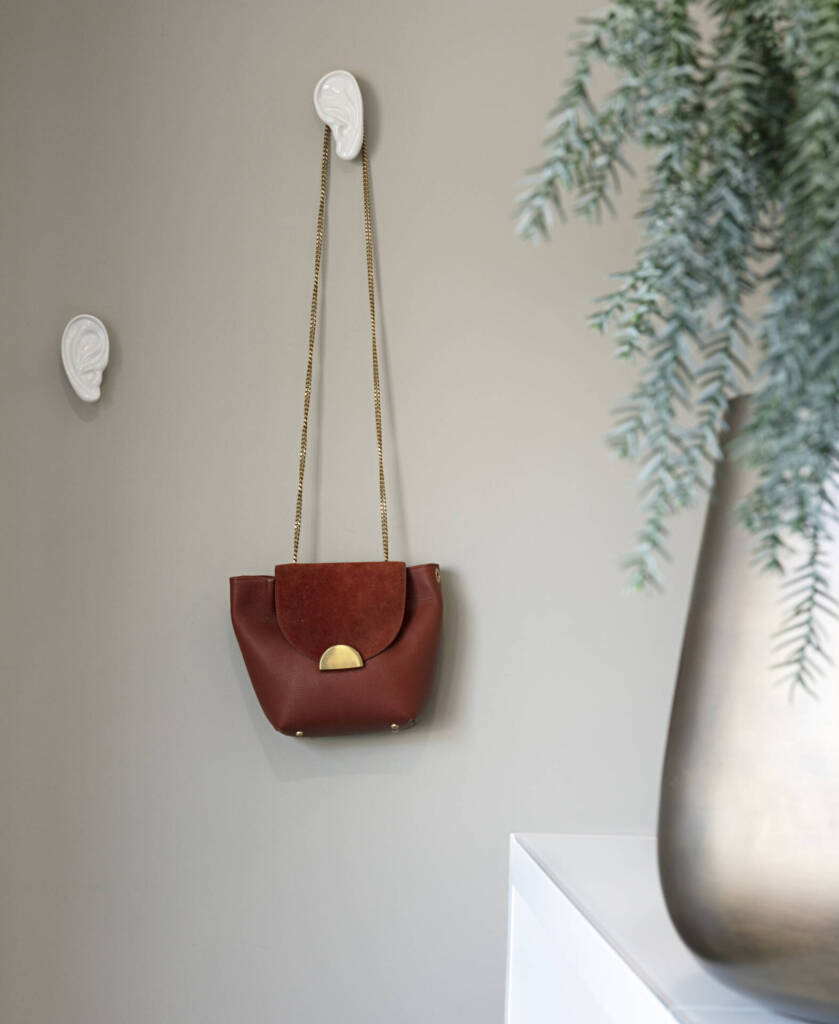 Détail d'un sac en cuir brun rouge accroché sur des oreilles en platre, par Amélie Beaumont, Architecte d'intérieur UFDI à Nantes et Pays de Loire 44