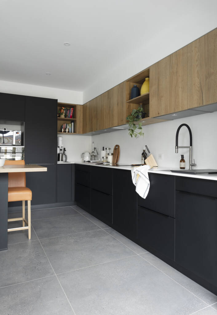 Une cuisine noire mixée de chêne clair effet brut pour les éléments hauts, par Amélie Beaumont, Architecte d'intérieur à Nantes et Pays de Loire UFDI 44