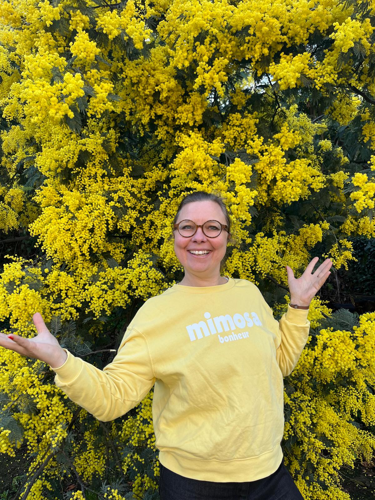 Amélie devant des mimosas en fleurs